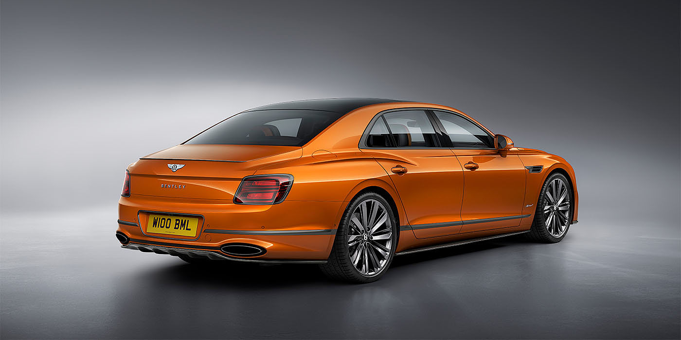 Bentley Milano Bentley Flying Spur Speed in Orange Flame colour rear view, featuring Bentley insignia and enhanced exhaust muffler.